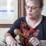A middle aged woman is rattling over a woman's chest