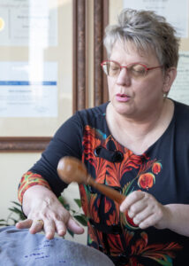 Rattling over a woman - Mammoth Hills Coaching and Wellness, LLC A middle aged woman is rattling over a woman's chest