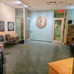 A cream and teal waiting room is softly lit and depicts chakra images on the walls